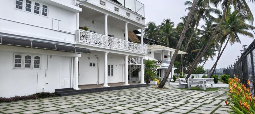 a white building with a balcony and a patio at The lawrences aqua stay in Cochin