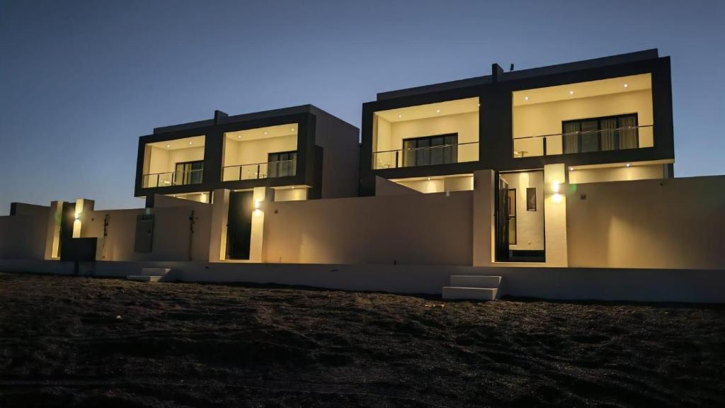 a large building with lights in front of it at Dune View Luxury Villas in Ḩawīyah