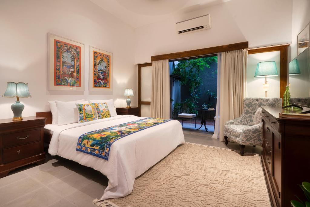 a bedroom with a bed and a chair and a window at Luna Mews - Ward place in Meda-Ela