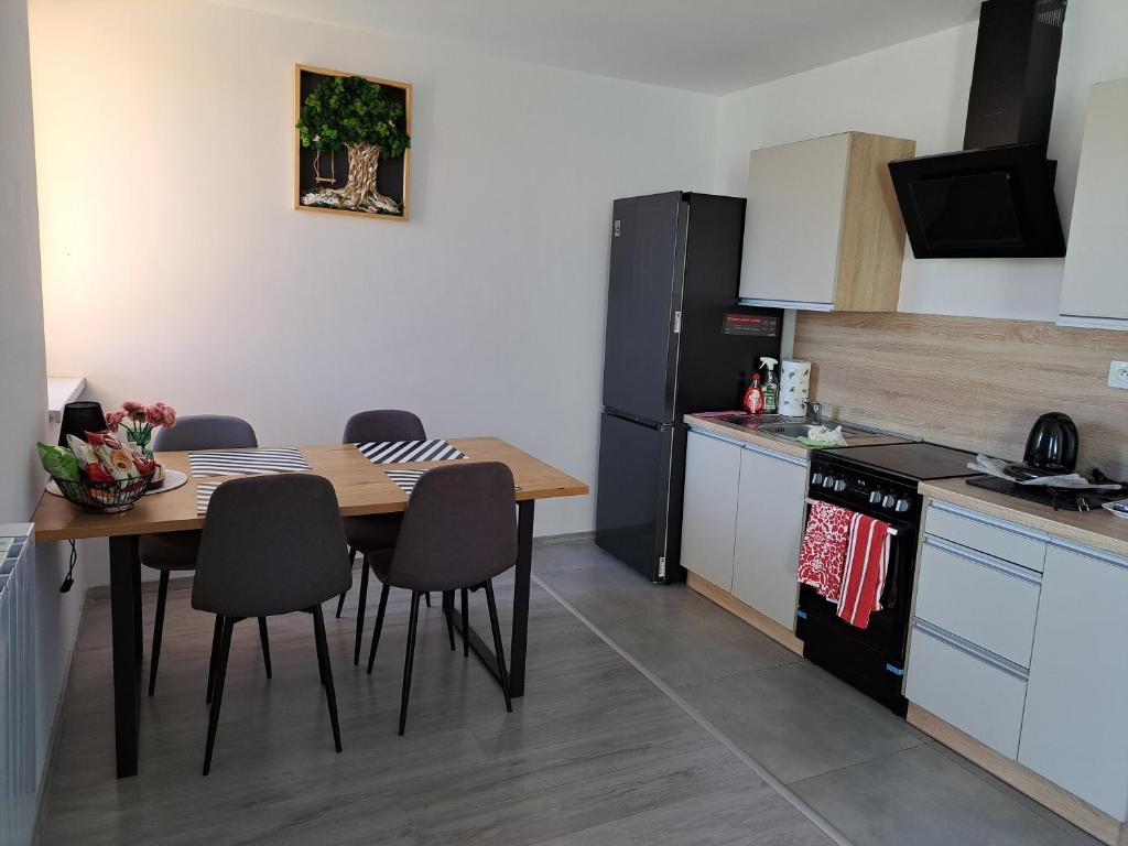 a kitchen with a table and chairs in a kitchen at Budget Apartment KNM5 in Kysucké Nové Mesto