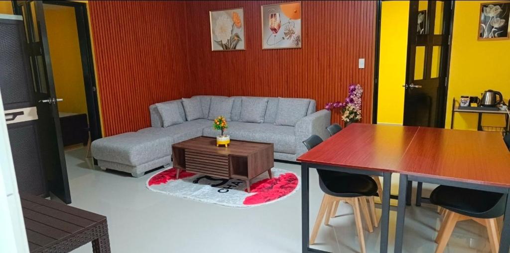 een woonkamer met een bank en een tafel bij Jenessa's Bedsite, Suite 90 sqm, Aircon, 5G Wifi, Netflix in Cantilan