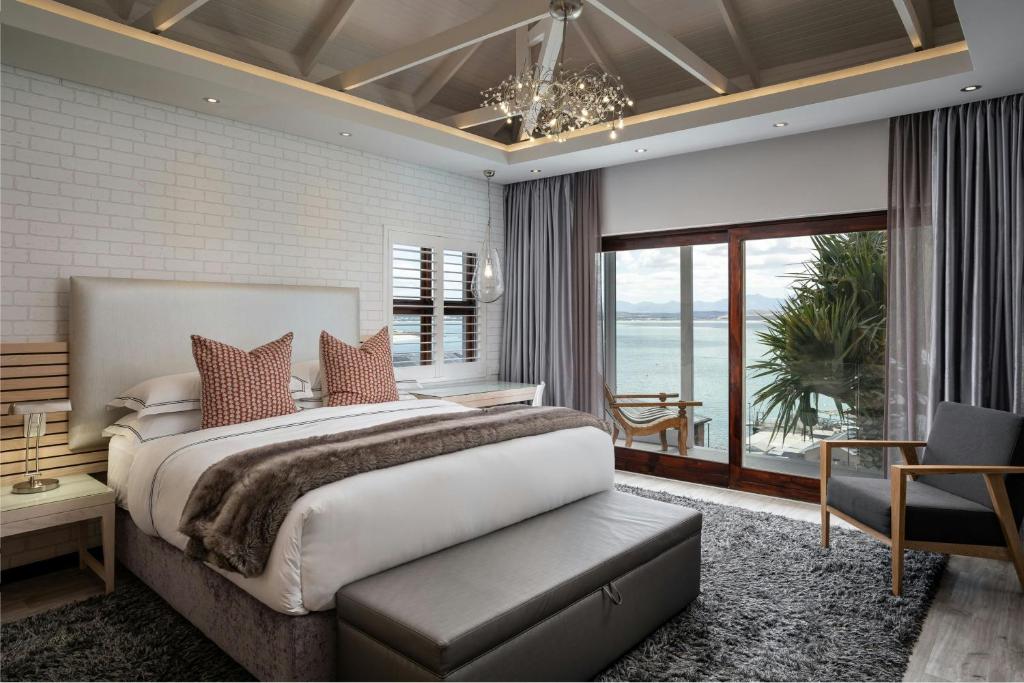 a bedroom with a large bed and a large window at Protea Hotel by Marriott Mossel Bay in Mossel Bay