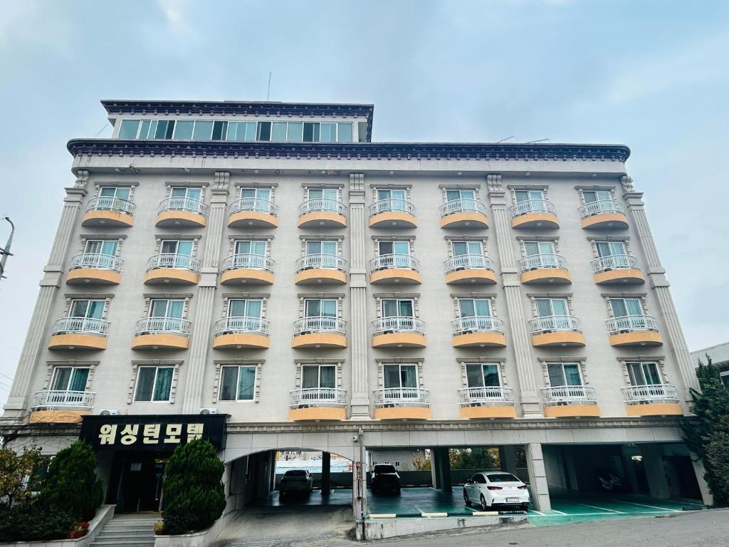 a large building with a car parked in front of it at Washington Motel in Gangneung