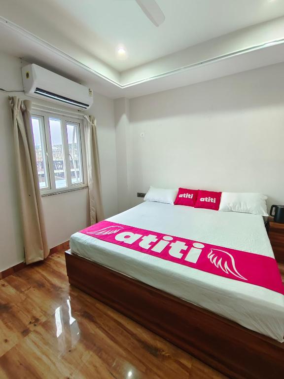 a bedroom with a bed with a red and white blanket at Atiti Signature room 109 , zero mile in Patna