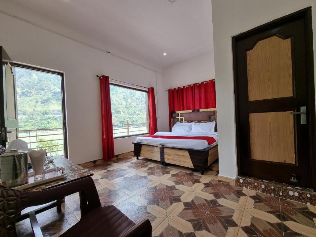 a bedroom with a bed and a large window at Chamera Inn Homestay in Chamba
