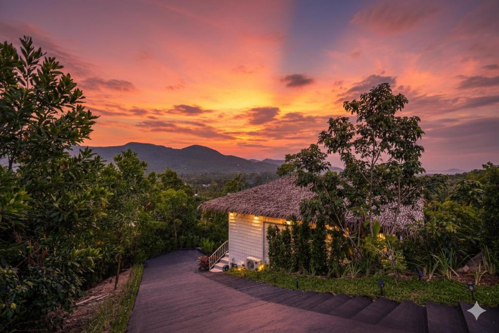 a building with a sunset in the background at Archie s Paradise View in Ko Phangan
