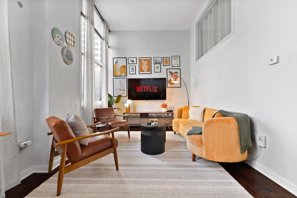 a living room with two chairs and a tv at Downtown Indy 2BR - Stadium, Convention - Arcade Games - Skywalk in Indianapolis