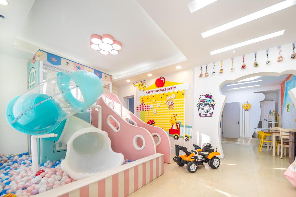 Una habitación infantil con zona de juegos y un coche de juguete. en 青岛旺莎主题民宿, en Qingdao