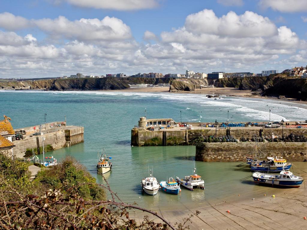 a group of boats docked in the water near a beach at 1 Harbour View in Newquay