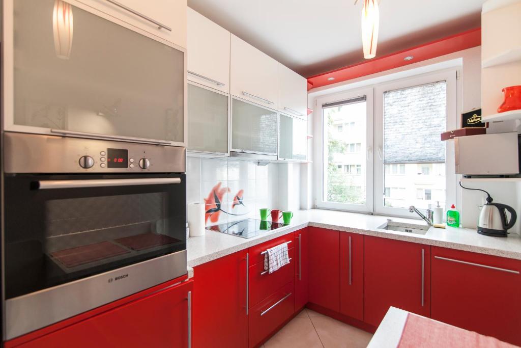 a kitchen with a stove top oven and a microwave at Apartamenty Białystok - Marii Skłodowskiej-Curie 6 in Białystok