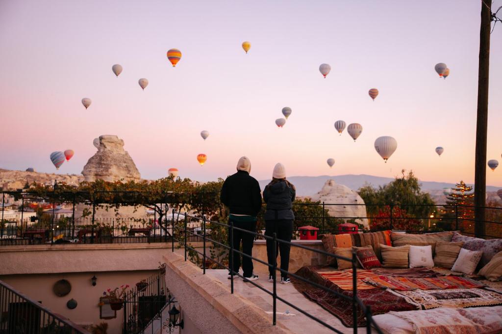 two people standing on a balcony looking at hot air balloons at Paradise Cappadocia Hotel in Goreme