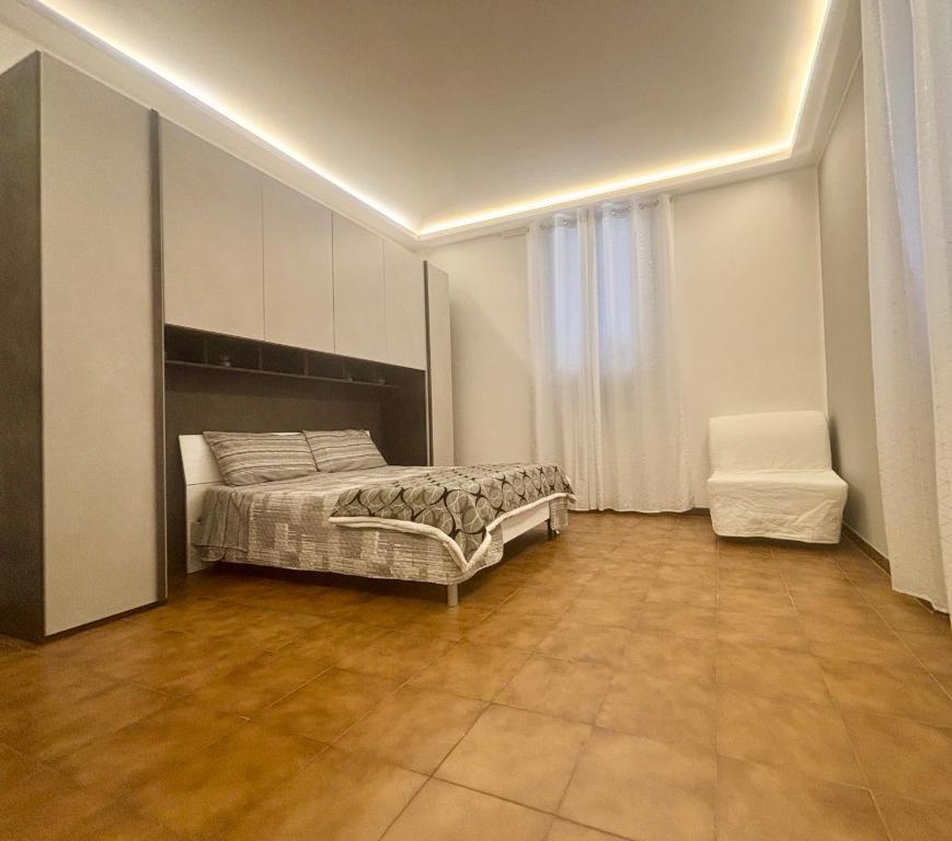 a bedroom with a bed and a chair at Casa Edoardo Forum Assago & Rozzano Humanitas in Rozzano