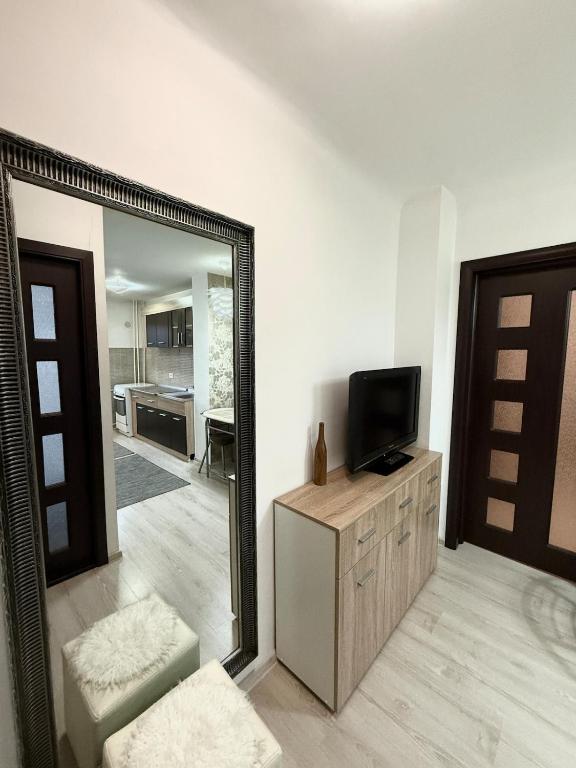 a mirror in a living room with a television on a dresser at Apartament Densia in Craiova close to the center in Craiova