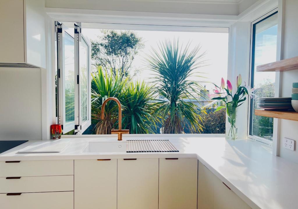 a kitchen with a sink and a large window at Top of Tyne - Peace, Comfort & Local Connection in Oamaru