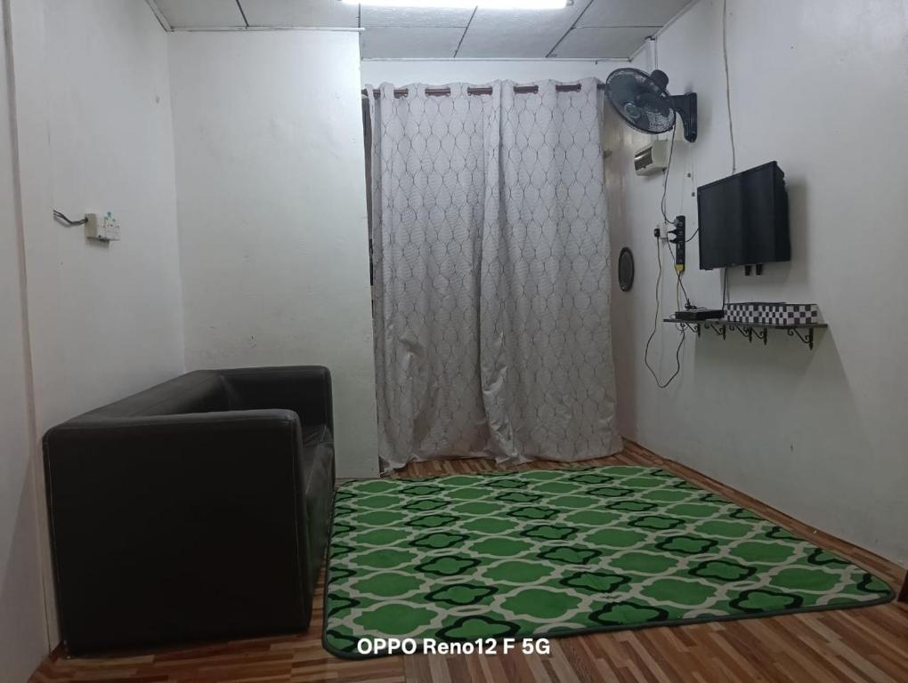 Una sala de estar con un sofá y una cortina. en Qmar D Sepang, en Sepang