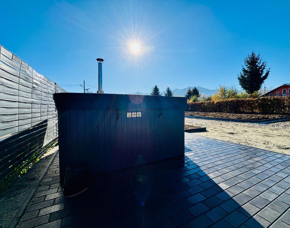 a trash can sitting on a sidewalk with the sun in the sky at Secret Forest Avrig By Erwin in Avrig
