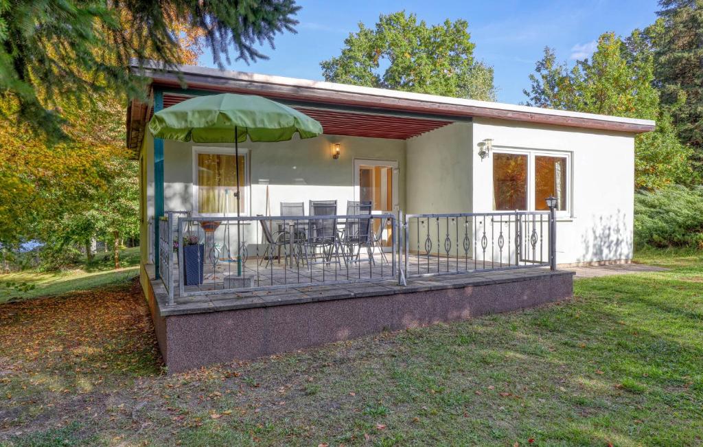 a small house with a balcony with an umbrella at Ferienhaus Boitzenburger Land in Rosenow