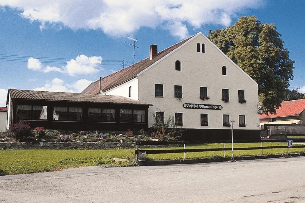 ein weißes Gebäude mit einem Schild an der Seite in der Unterkunft Gasthof Pflamminger in Wörth an der Donau