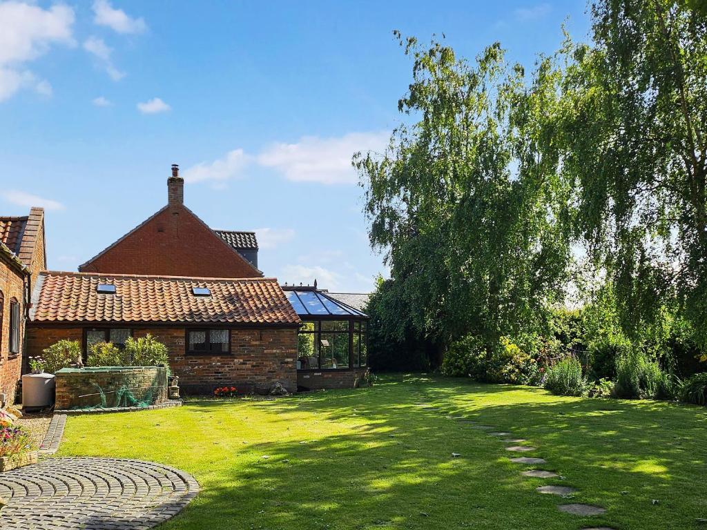 a house with a large yard with a tree at Elm Barn View in Freethorpe
