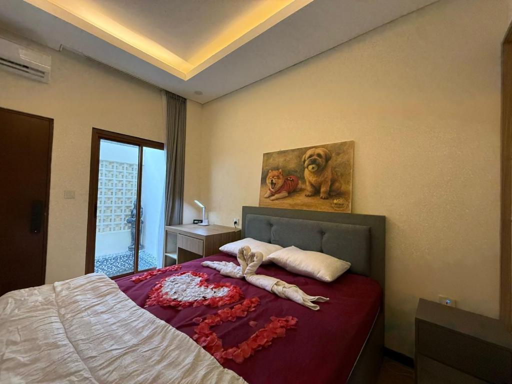 a bedroom with a bed and a painting of a dog at villa koku kuta in Legian