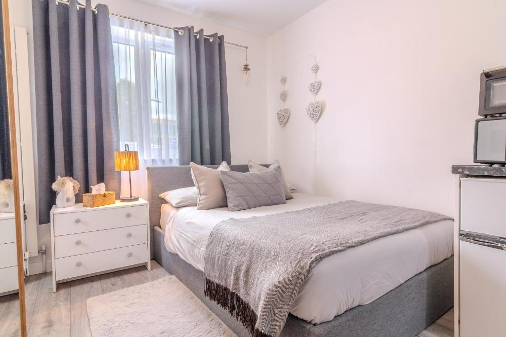 ブロムリーにあるCosy Studio Flatのベッドと窓のある小さな寝室