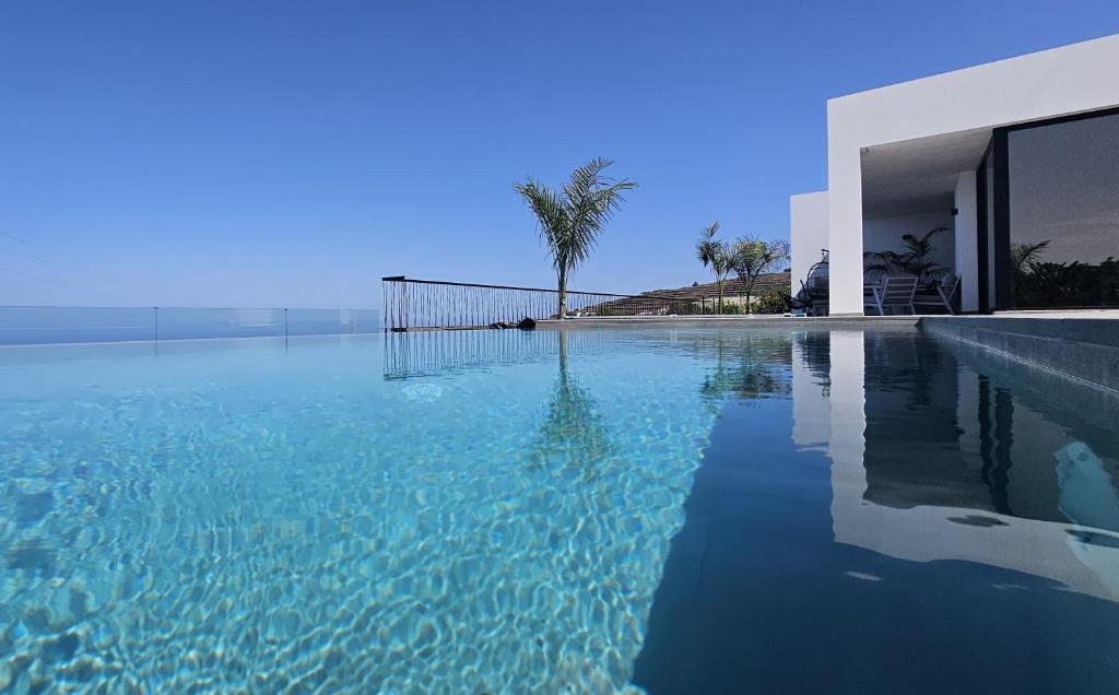 una gran piscina de agua junto a una casa en Casa Laina, en Tijarafe