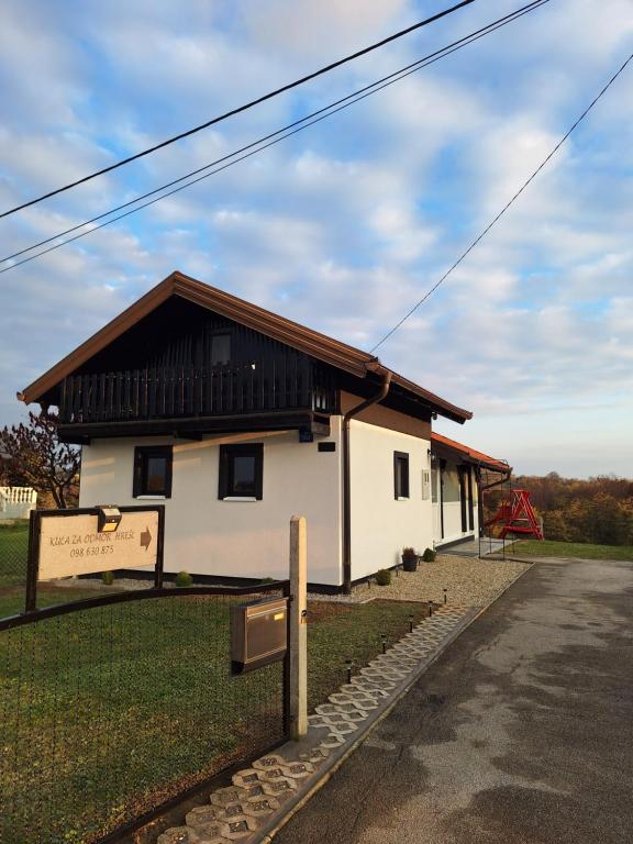 a white house with a black roof and a street at Kuća za odmor Hrešć in Donji Koncovčak