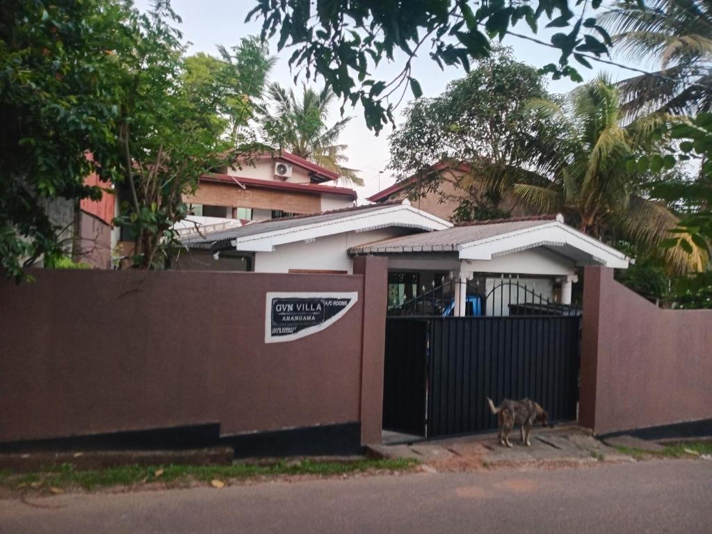 a dog standing in front of a gate of a house at GVN villa in Ahangama