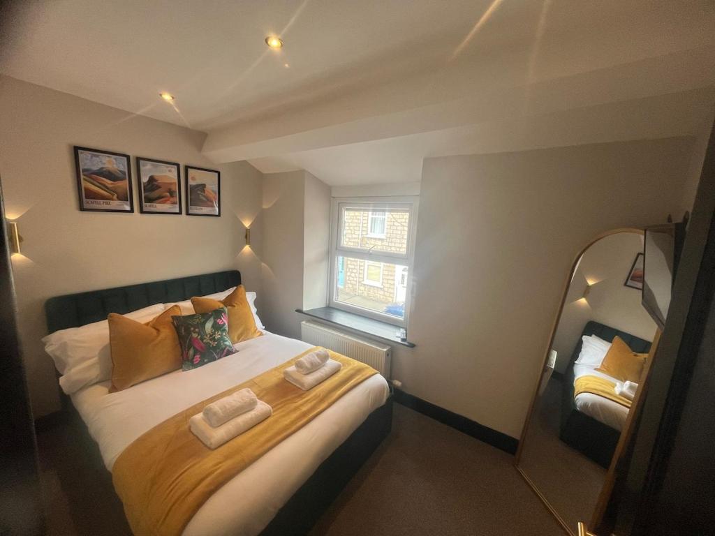 a small bedroom with a bed with two towels on it at Mint Cottage - pet friendly house in Kendal in Kendal