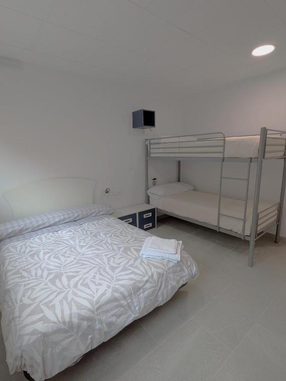 a bedroom with a bed and a bunk bed at Albergue Pundak Valle del Jerte in Cabezuela del Valle