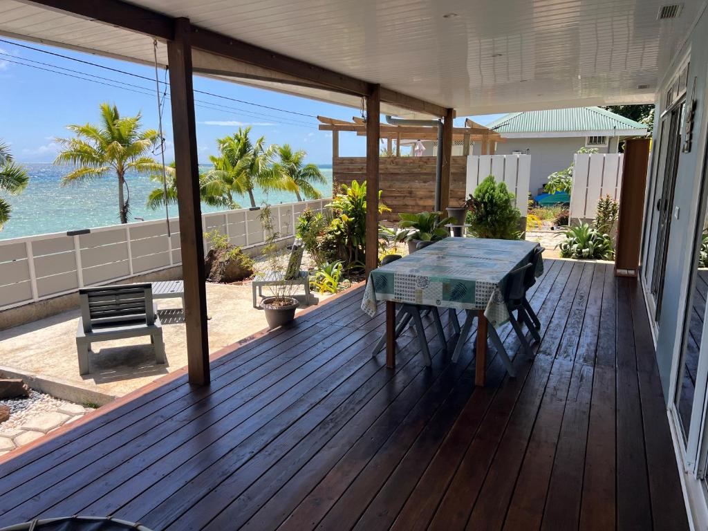 a wooden deck with a table on a house at Blue Essence Tahaa in Tahaa