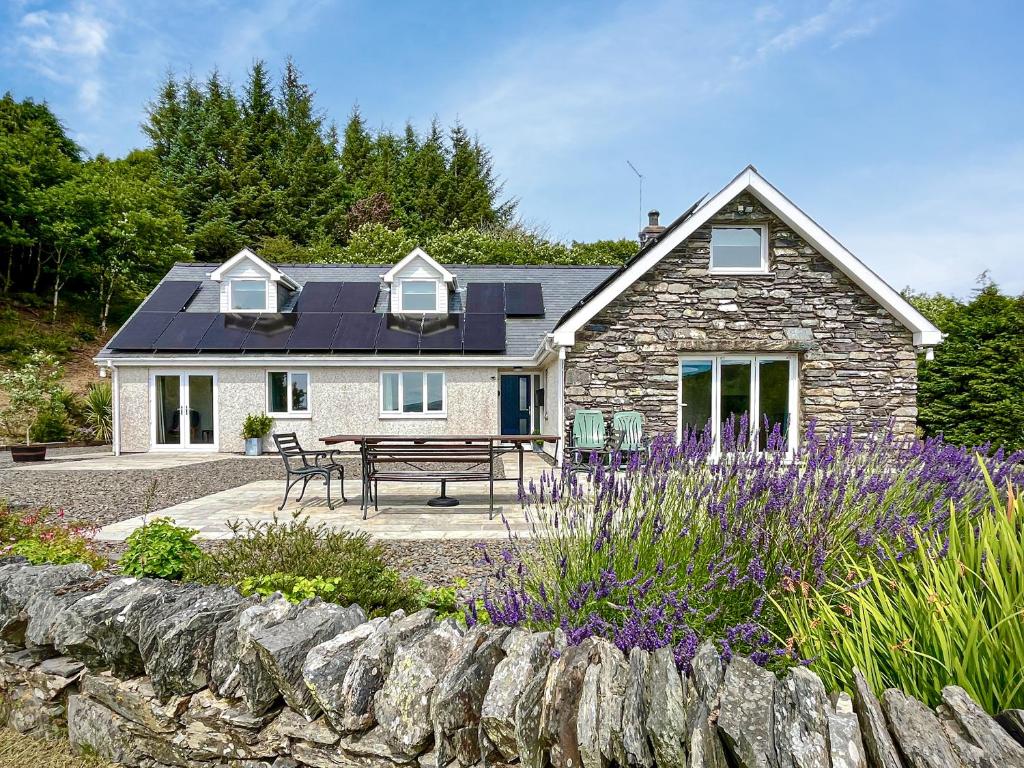 a stone house with a picnic table in front of it at Bryn Derw in Barmouth