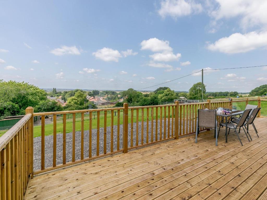 a wooden deck with a table and chairs on it at Hill Crest Lodge 2 in Hemswell