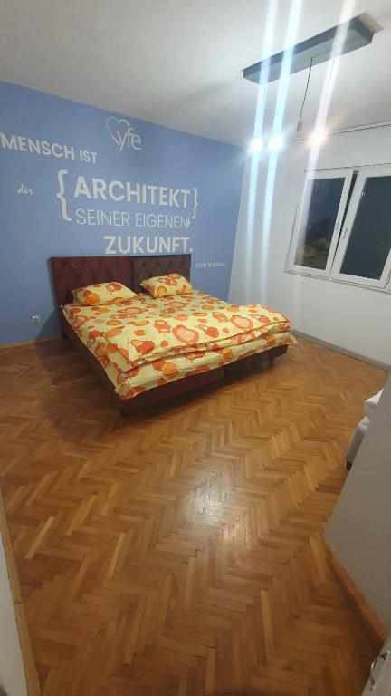 1 dormitorio con 1 cama en el suelo de madera en shared rooms, en Pristina