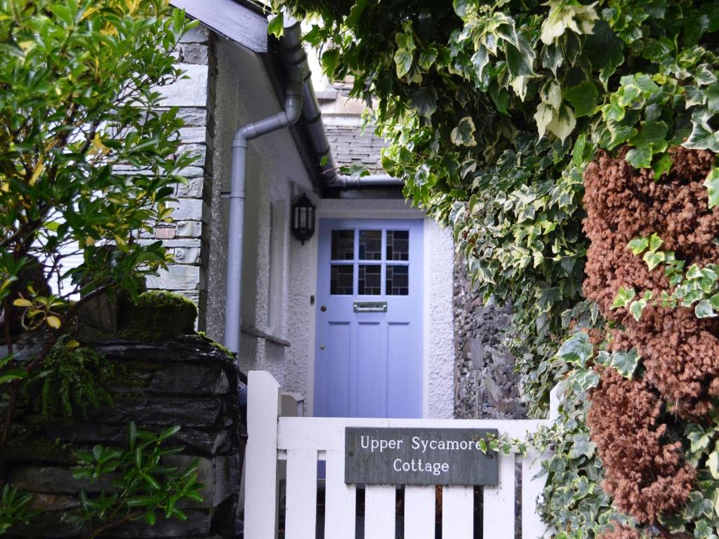 a white gate in front of a white door at Upper Sycamore Cottage in Ambleside