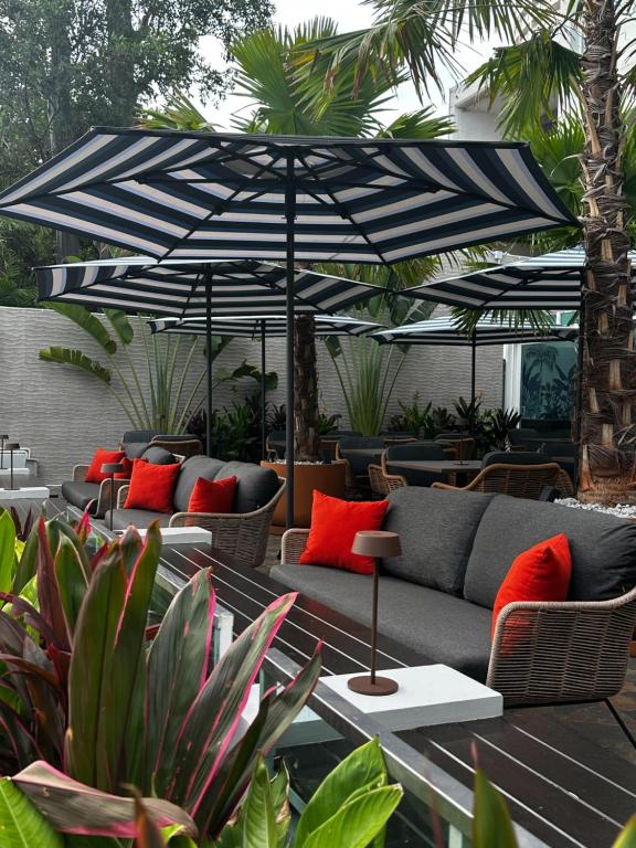 a patio with a couch and an umbrella at Gooseberry Baan & Bistro in Pattaya South