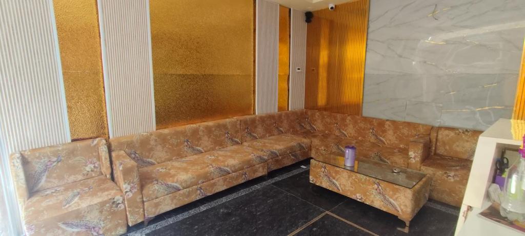 a brown leather couch in a room with a table at Baghdad Palace Near Dargah sharif in Ajmer