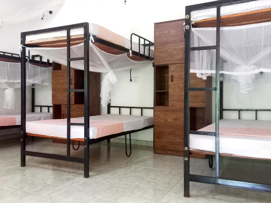 una habitación con tres literas en una habitación en Eco Pavilion, en Sigiriya