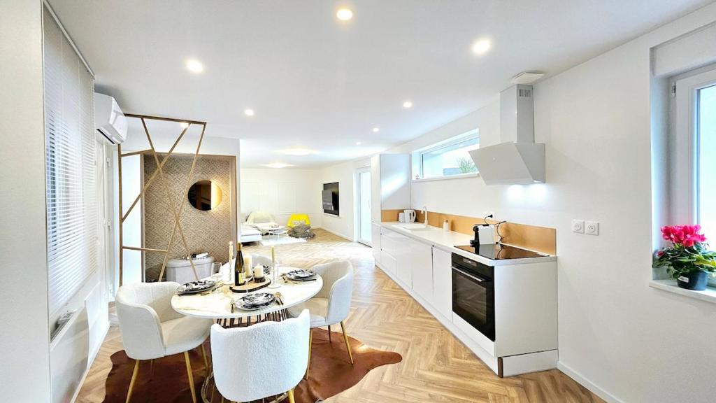een keuken met een tafel en stoelen in een kamer bij La signature d'Alsace in Bennwihr