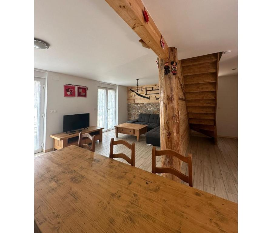 ein Wohnzimmer mit einem Holztisch und einer Couch in der Unterkunft Gîtes pour 2 à 6 personnes Manala et Vivala in Metzeral