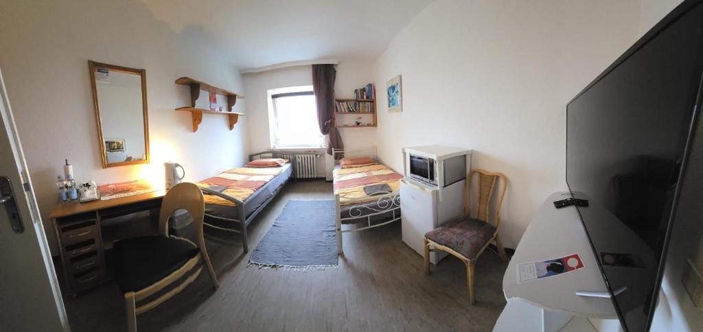 Kleines Zimmer mit einem Schreibtisch und einem Bett. in der Unterkunft REST-ATILA in Hannover