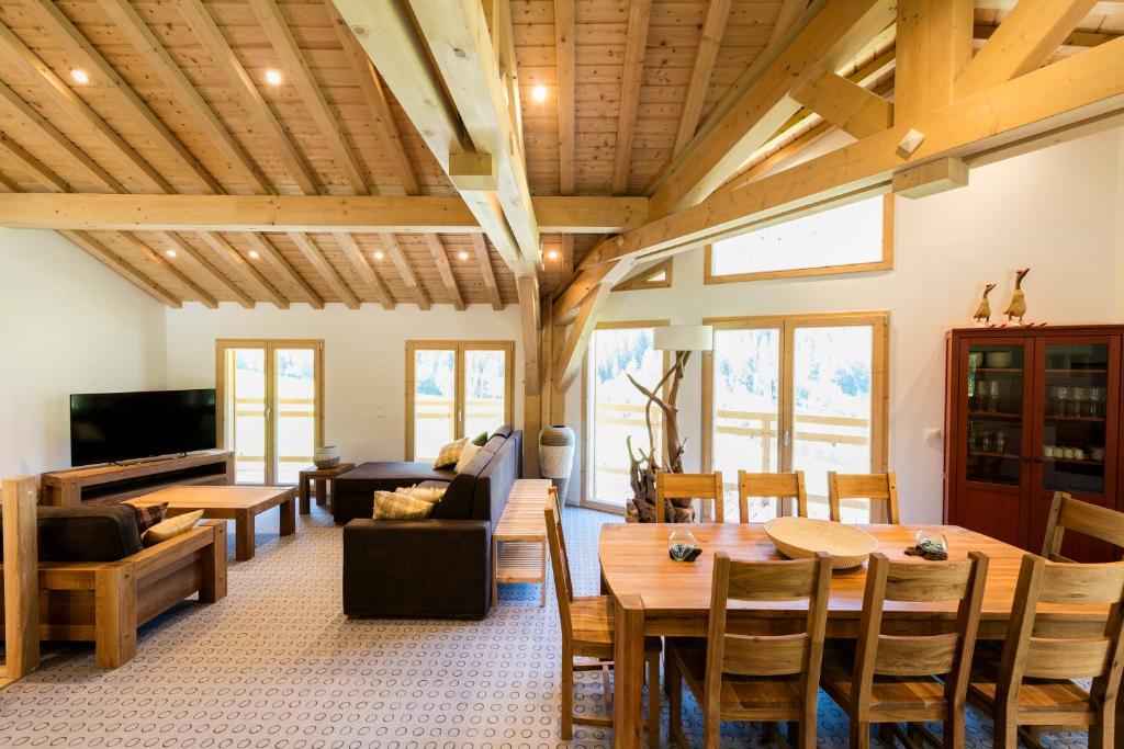 a living room with wooden ceilings and a table and chairs at Chalet Les Amis in Peisey-Nancroix