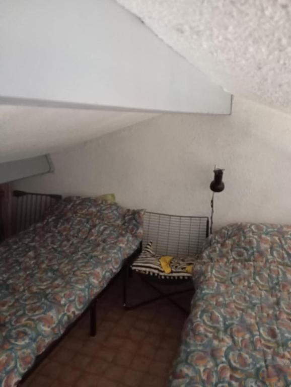 a room with two beds and a bench in it at Le Charme des Barcarelles in Le Barcarès