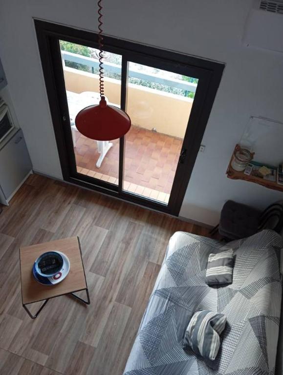 una camera con un letto, un tavolo e una finestra di Le Charme des Barcarelles a Le Barcarès