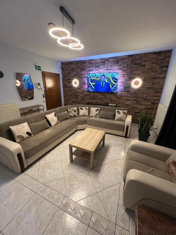 a living room with couches and a tv on a brick wall at Diamond Stay in Kilkís