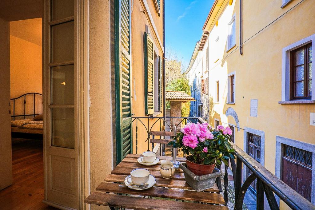 a table on a balcony with flowers on it at Casa Sofia in Cannobio