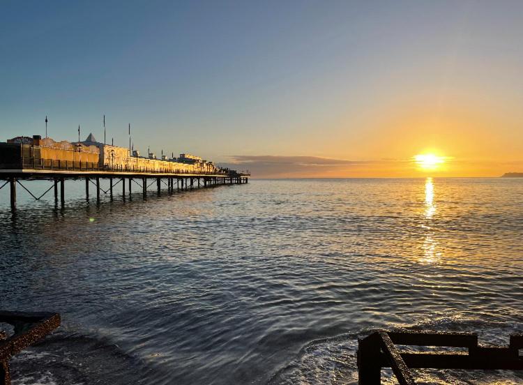 une jetée sur l'eau avec un coucher de soleil dans l'établissement PINK HOUSE ,Opposite PIER & Beach ,SLEEPS 6 , 2 BEDROOM GROUND FLOOR SELF CONTAINED GARDEN FLAT , PRIVATE ENTRANCE , KITCHEN , Guaranteed Parking ,Wifi , Movies ,Bathroom ,fridge , microwave ,BEDROOM 1, DOUBLE BED & 2 SINGLE BEDS ,BEDROOM 2 , DOUBLE BED, à Paignton