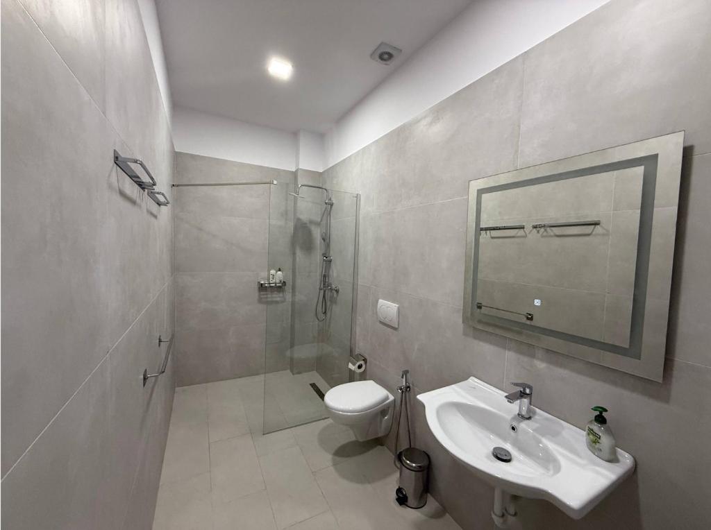 a bathroom with a toilet and a sink and a shower at Palita Vita - Durrës Beach in Durrës