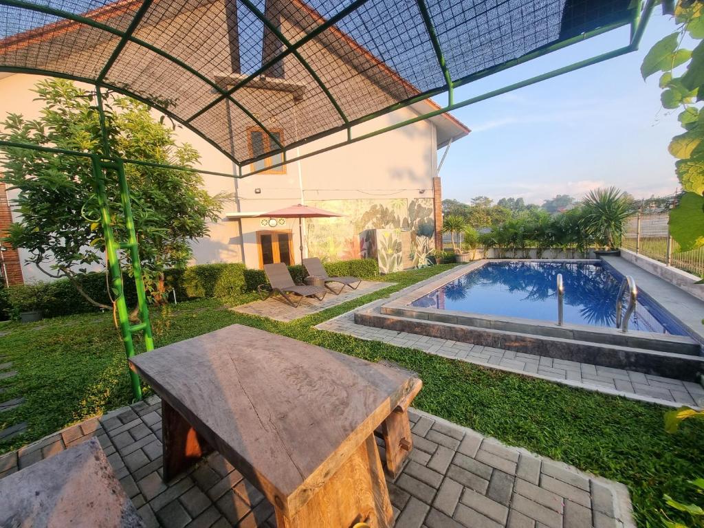 un patio al aire libre con banco y piscina en D'Jongke Village, en Beran-kidul