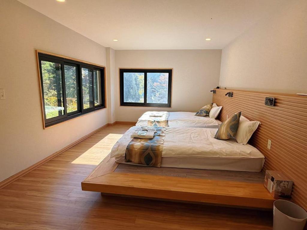 a large bedroom with a large bed and windows at 苗場サンバレーホテル in Minami Uonuma